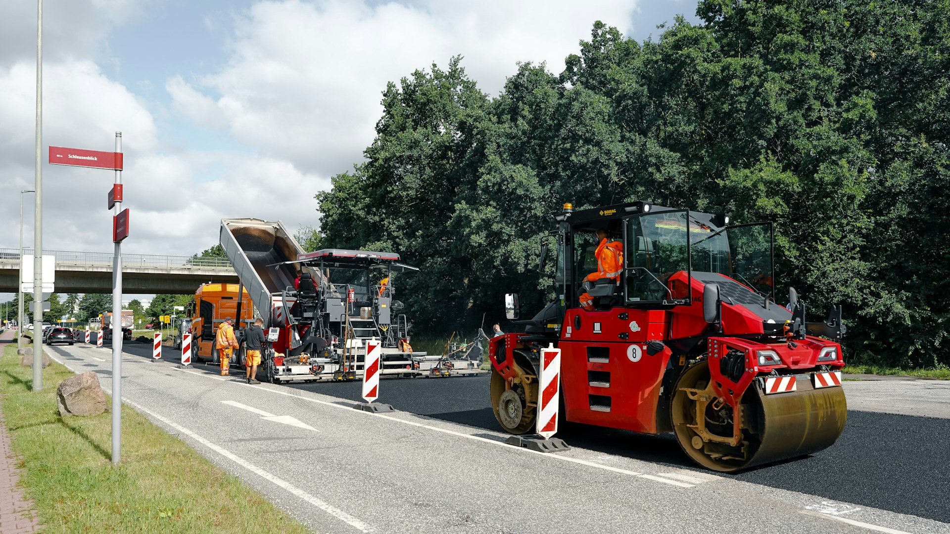 Obra de pavimentação com rolo compactador e pavimentadora